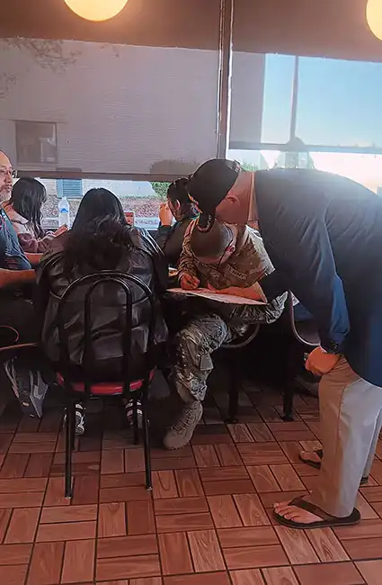 The author and Veteran David Haave shares his love sharing his books with a soldier and